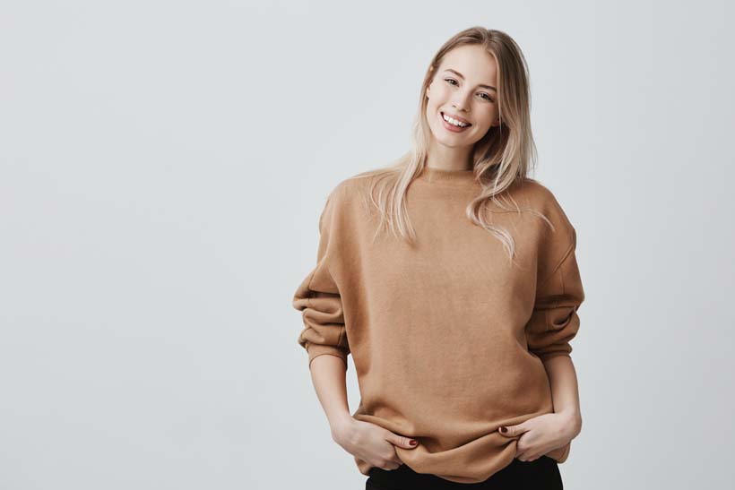 portrait-young-woman-casual-clothes-with-blonde-dyed-hair-gently-smiling-pleasant-conversation-standing-closed-posture_1.jpg